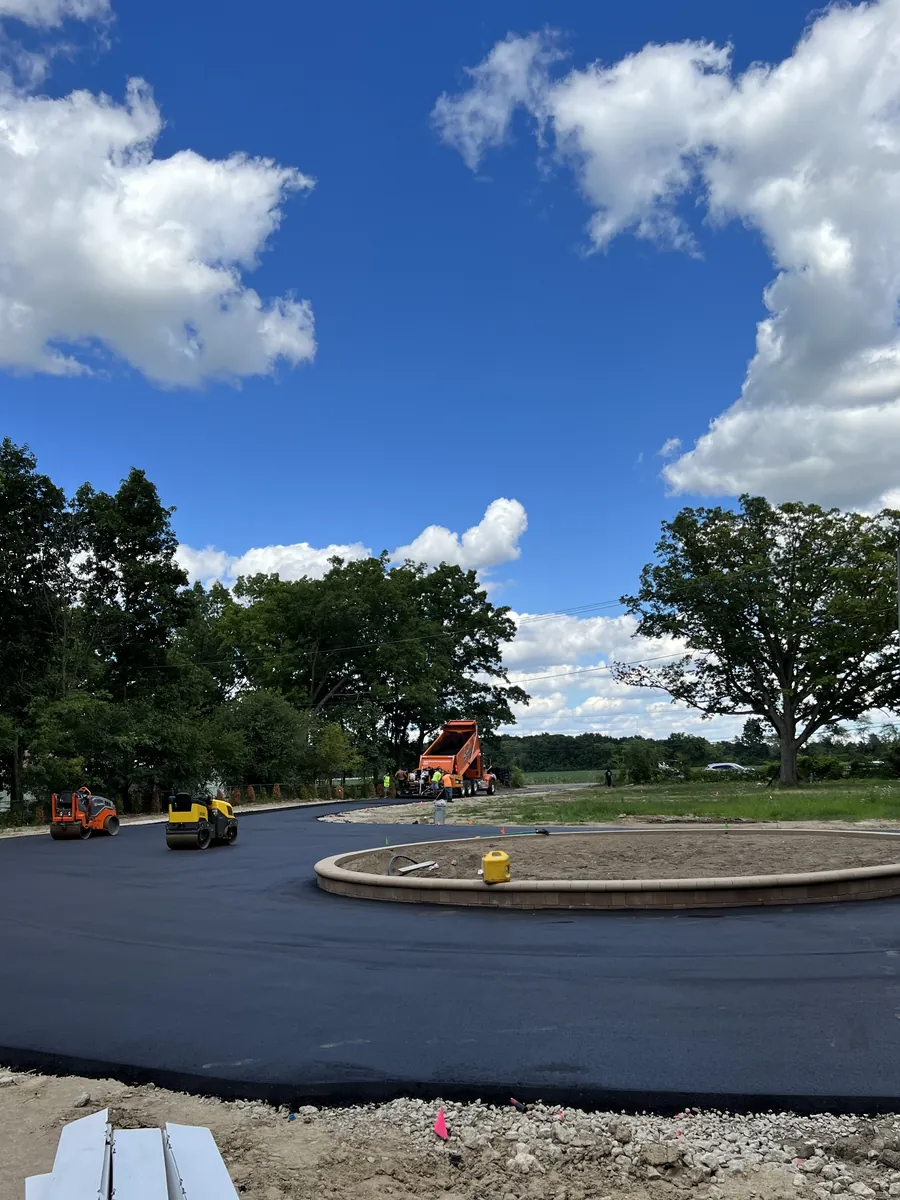 Freshly paved cul-de-sac loop around a landscaped island under a blue sky