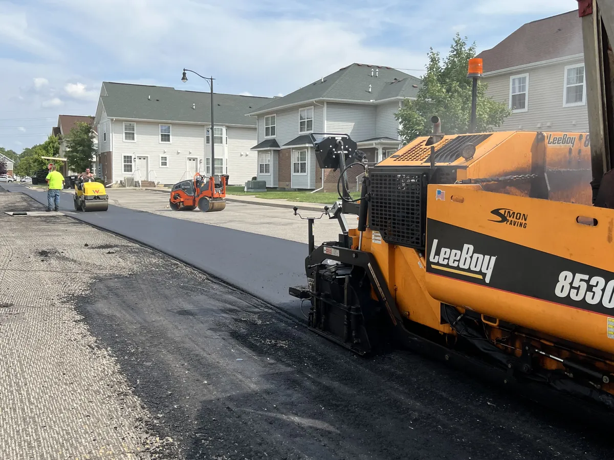 LeeBoy 8530 paver laying a fresh lane of asphalt down a residential street